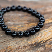 Armband aus Onyx-Steinen auf Holz